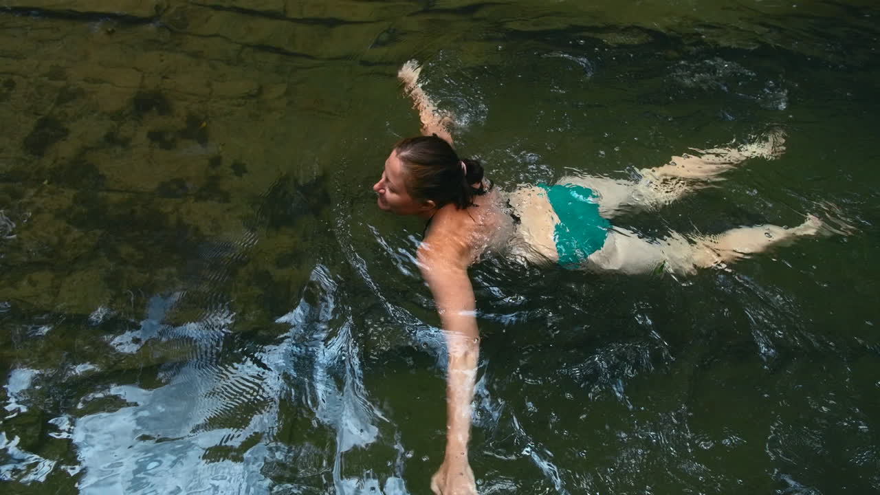 Donna che nuota in una piscina naturale