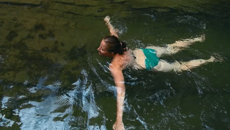 mujer nadando en una piscina natural