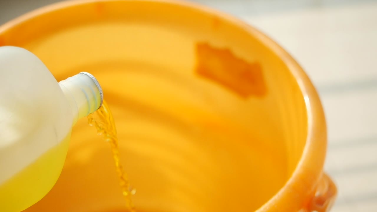Pouring liquid into a plastic bucket