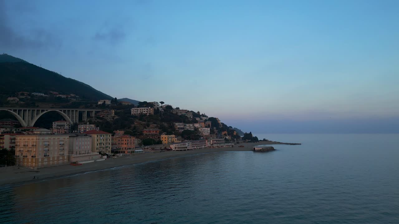 Veduta aerea della spiaggia di Varazze con edifici colorati durante l'ora blu