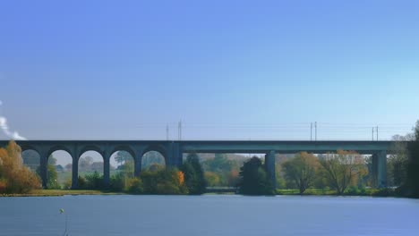 a time-lapse shot of a lake and a railway bridge in a long shot