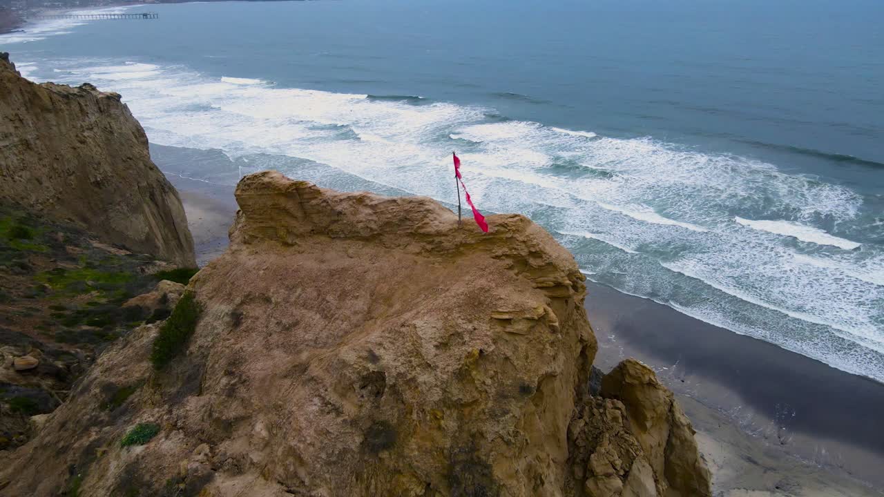 vista aérea de una bandera roja rota en el acantilado en blacks beach torrey pines california
