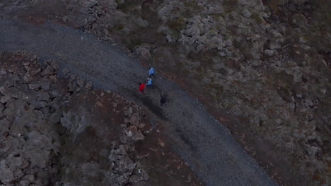 Overhead-view-four-people-walking-pathway-in-rocky-desolated-highlands-in-Iceland.-Top-down-view-of-group-tourist-mountaineering-strolling-trail-trekking-outdoors