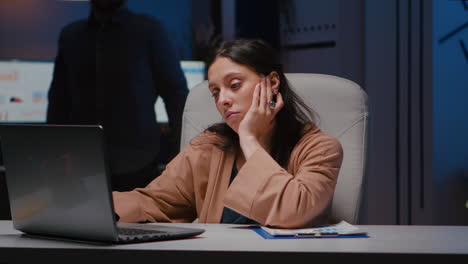 Portrait-of-exhausted-workaholic-manager-checking-economic-statistics-using-laptop-computer