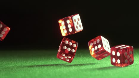 red dice falling and bouncing on green table on a dark background. shot on super slow motion camera 1000 fps.