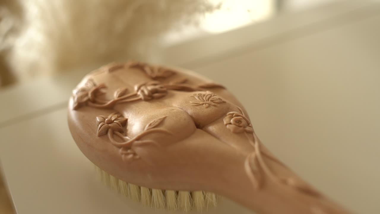 Wooden brush for the body lies on a table in the sunlight