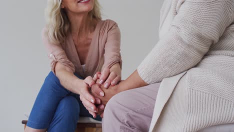 Two-diverse-senior-couples-sitting-in-circle-having-a-therapy-conversation-at-home