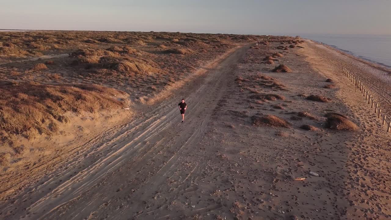 Young man running in the desert landscape