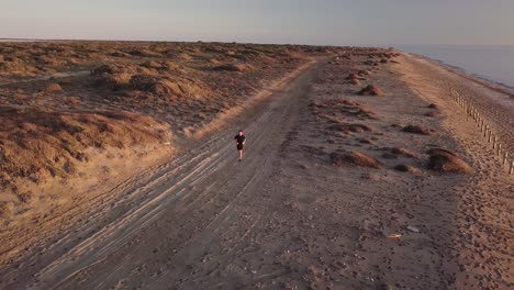 young man running in the desert landscape