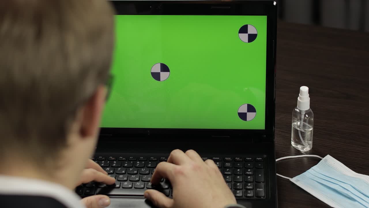 hombre tiene videoconferencia de llamada en portátil con pantalla verde. trabajo a distancia en línea