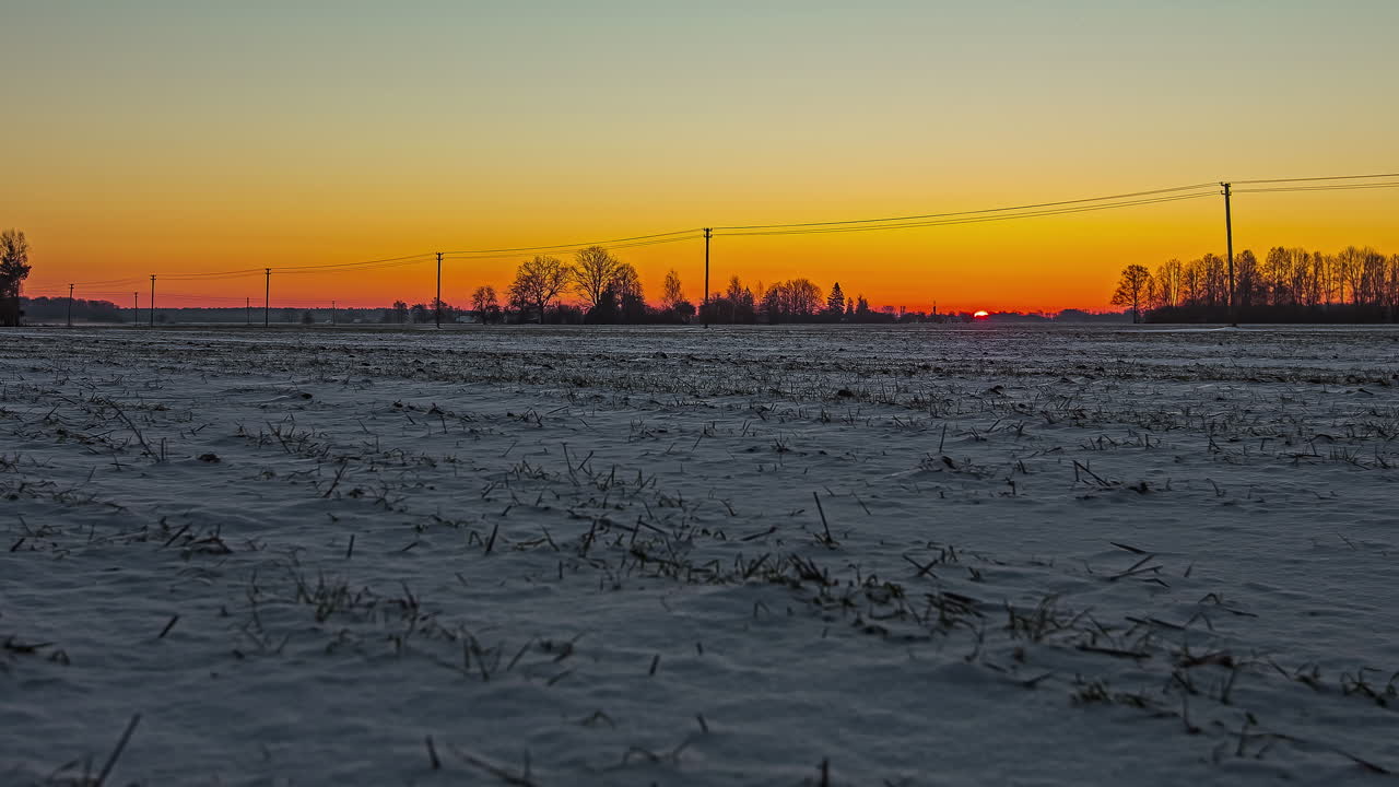 일출이 눈으로 뒤덮인 농지를 비추는 황금빛 새벽 - 시간 경과