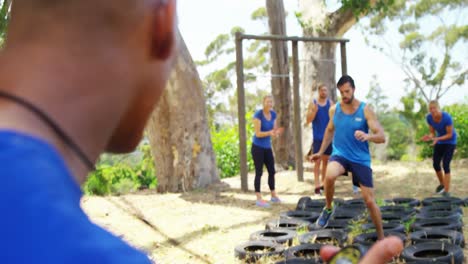 personas en forma que practican el entrenamiento de carreras de obstáculos de neumáticos 4k