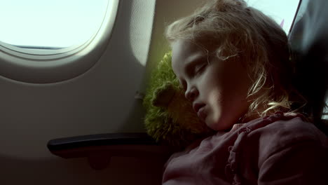 a little girl is sleeping in an airplane seat