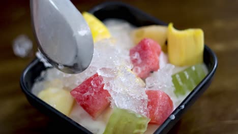 spoon scooping ice fruit dessert in hanoi