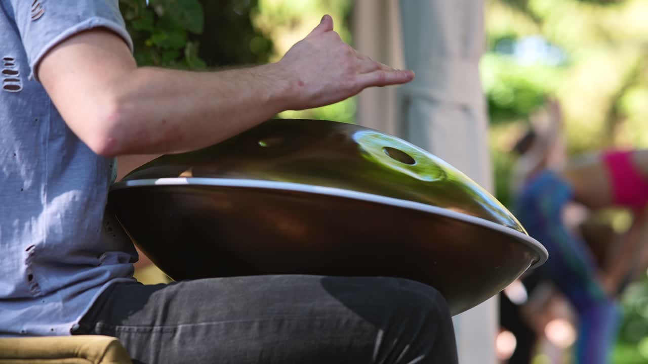 persona jugando al handpan en un parque