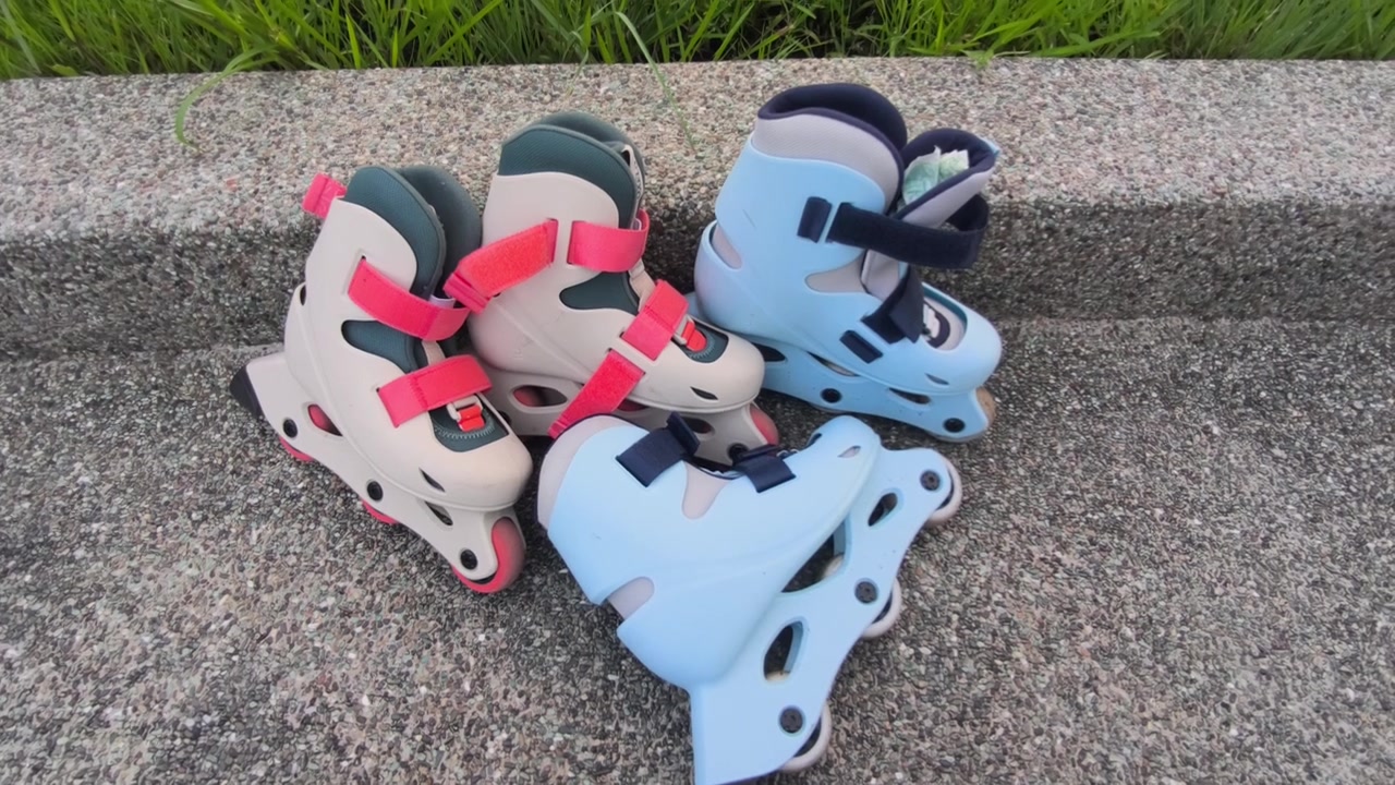 A pair of child-sized rollerblades rests on a smooth concrete bench after a fun skating session. The colorful inline skates sit quietly in the bright outdoor sunlight.