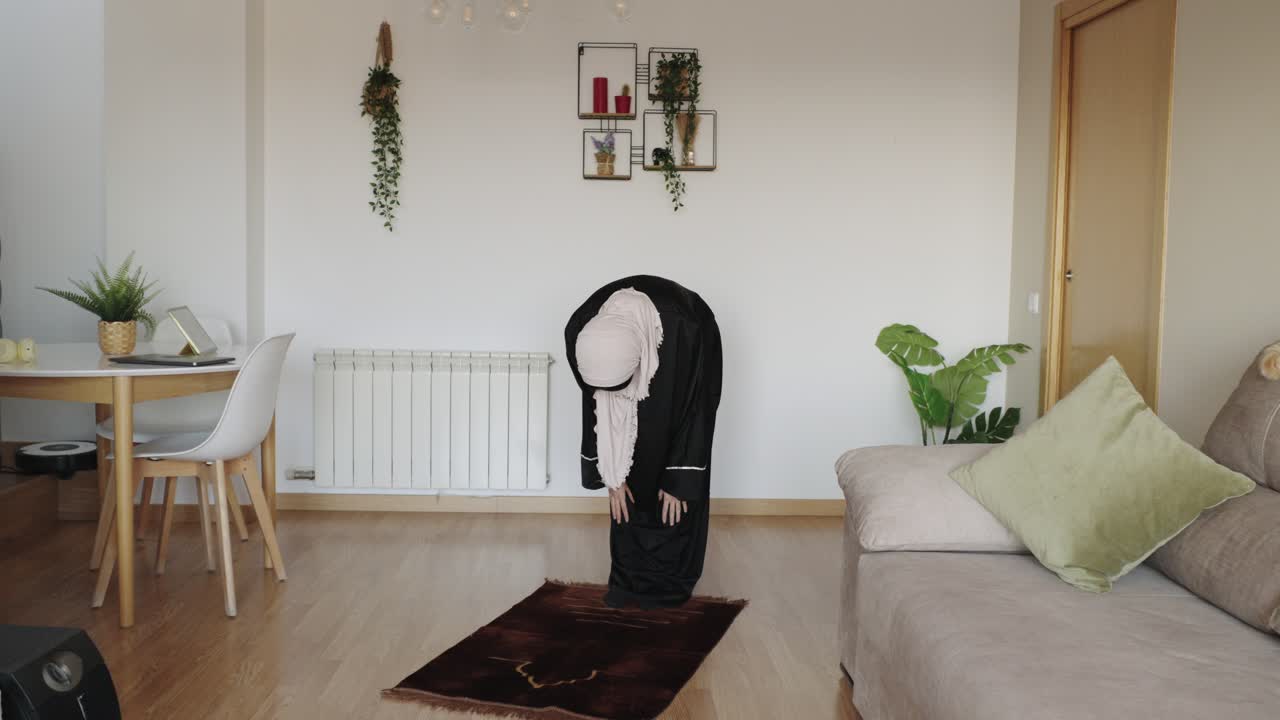 Muslim woman praying at home