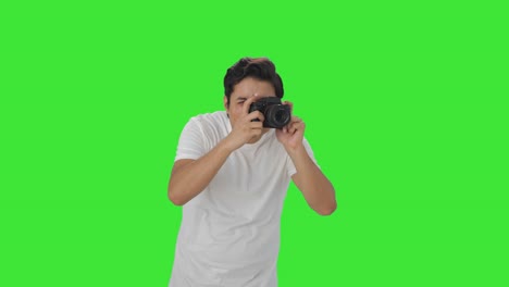 uomo indiano che fa clic su foto usando la schermata verde della fotocamera