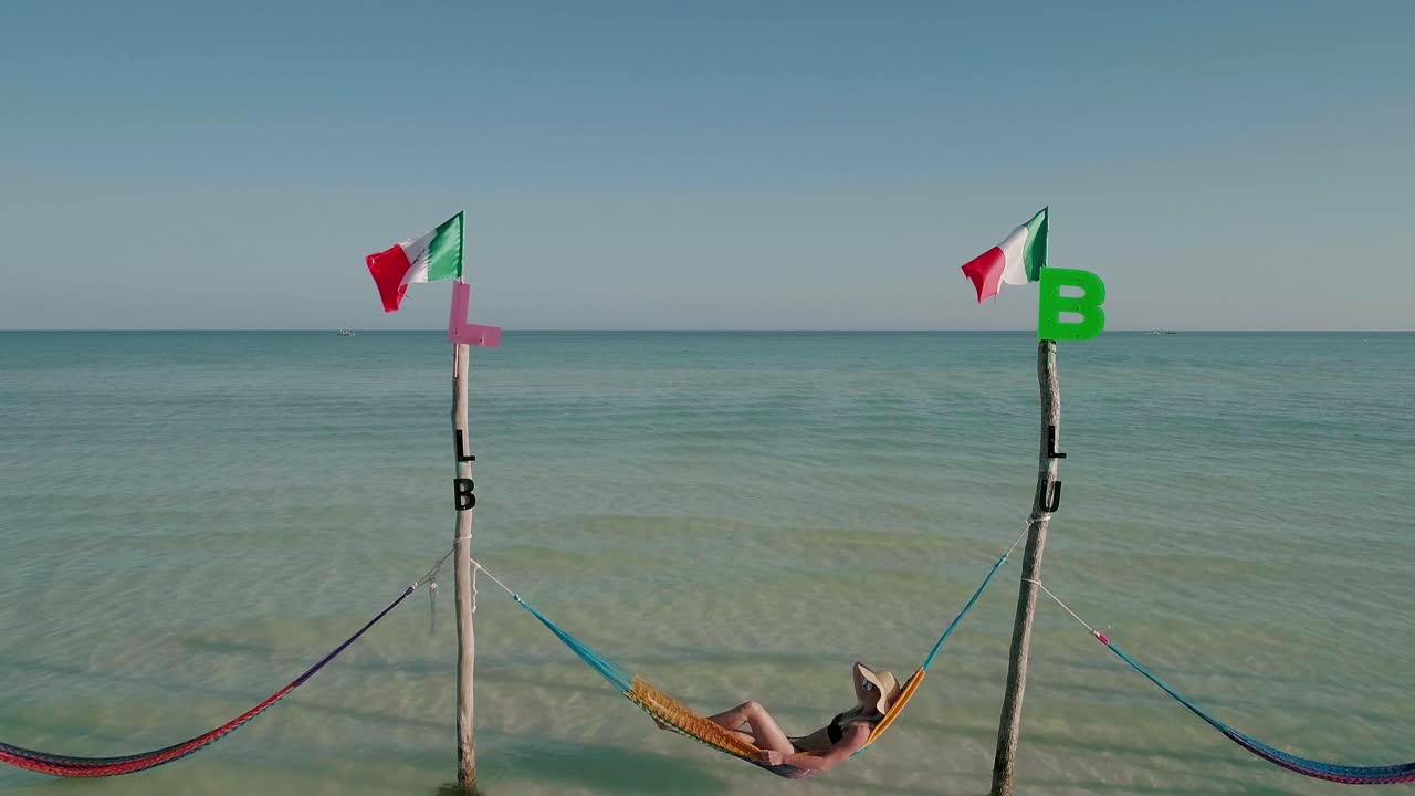 holbox 그물 침대에 누워 밀짚 모자와 여성 관광, 화창한 날