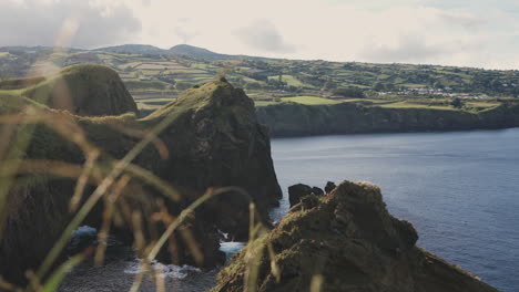 reveal pan of rural green coastal landscape and sea at the azores