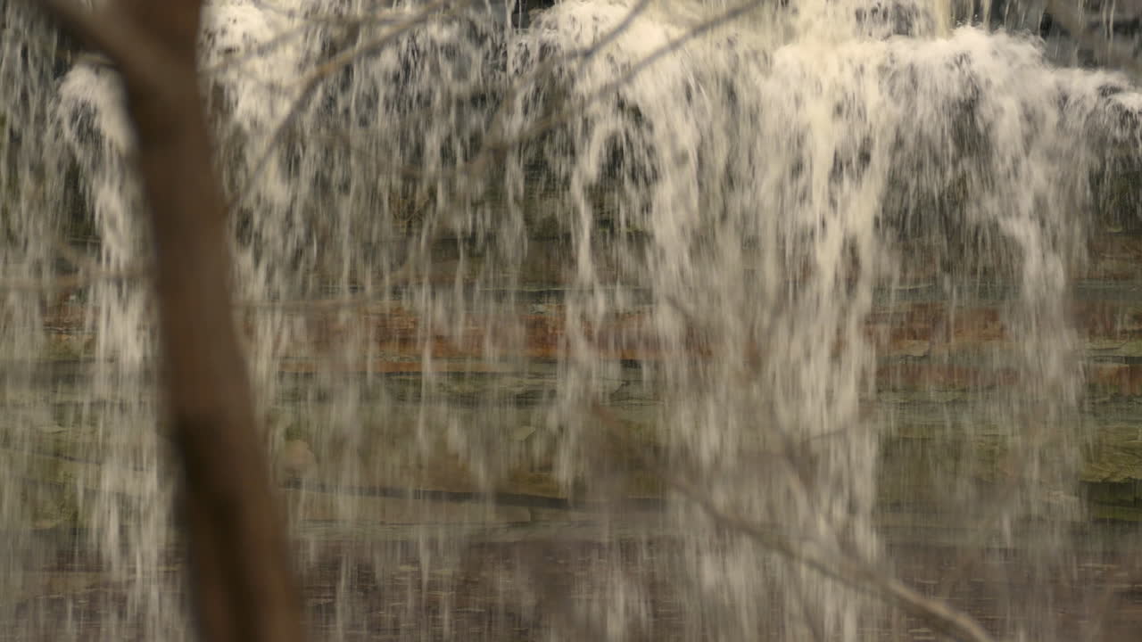 A view behind the waterfall: powerful stream of water is falling down