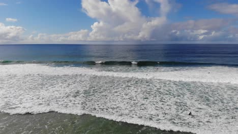 Eine-Drohne-Fliegt-Auf-Das-Meer-Zu-Und-Die-Tosenden-Wellen-Offenbaren-Surfende-Surfer