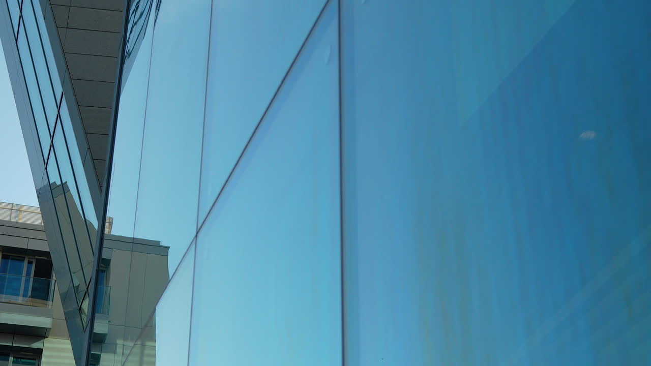 푸른 하늘을 반영하는 현대적인 유리 건물 전면, 기하학적 디자인, 도시 건축