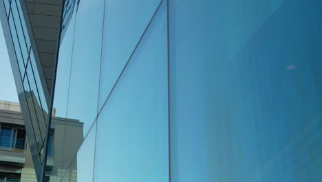 fachada de edificio de vidrio moderno que refleja el cielo azul, diseño geométrico, arquitectura urbana