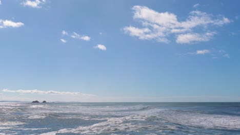 calm ocean waves under a clear blue sky at byron bay. steady camera captures serene coastal scenery with gentle motion