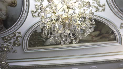 ornate ceiling with chandelier and paintings