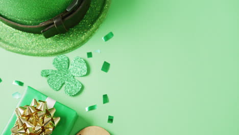 video de la hoja de trébol verde de san patricio, presente y sombrero con espacio de copia en fondo verde.