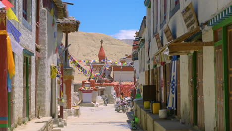 In-Einer-Gasse-Im-Oberen-Teil-Von-Mustang,-Nepal,-Gibt-Es-Alte-Stupas-Und-überall-Wehen-Buddhistische-Fahnen