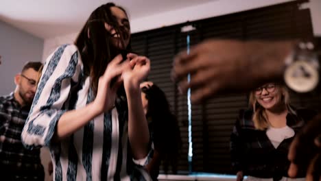 joven mujer de negocios caucásica exitosa celebrando su logro con amigos multiétnicos en una fiesta de baile en cámara lenta