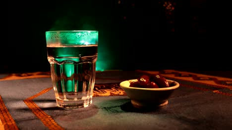 water and dates. iftar is the evening meal. slider view of decoration ramadan kareem holiday. festive greeting card, invitation for muslim holy month ramadan kareem. dark background. selective focus