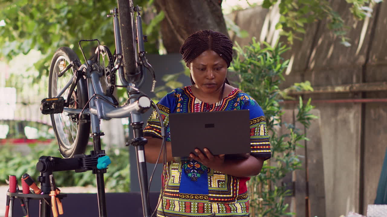 женщина обслуживает велосипед с ноутбуком