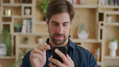 portrait-of-attractive-young-man-using-smartphone-texting-browsing-enjoying-mobile-communication-on-cellphone-technology-in-modern-home-background