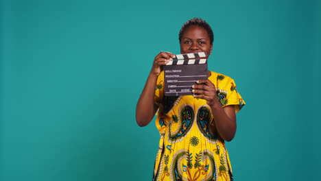 young woman movie producer clapping filming slate to cut a scene