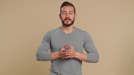 young lebanese man breathes deeply eyes closed meditating with concentrated thoughts peaceful mind