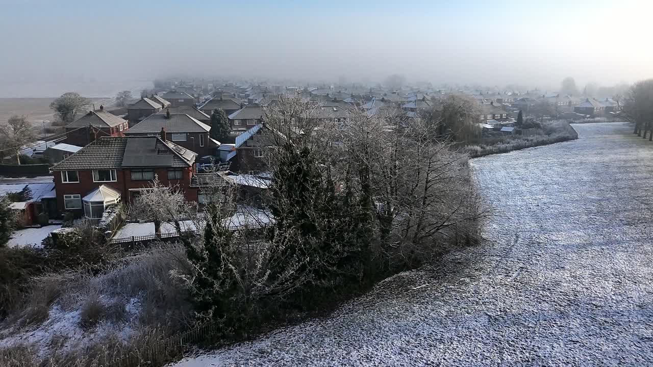 Frosty morning mist aerial view covering British small town neighbourhood houses