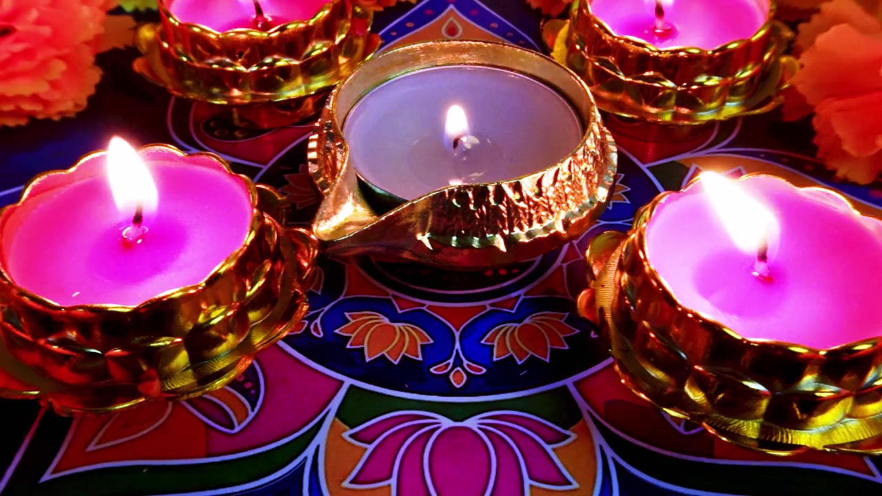 Candele Diwali accese su uno sfondo Rangoli colorato