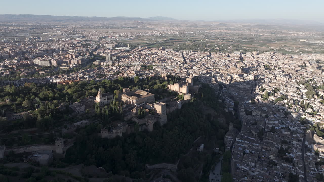 Ampia ripresa aerea cinematografica con drone di Granada e della fortezza del palazzo dell'Alhambra in Andalusia, Spagna, Europa, all'alba. Architettura islamica nasride e rinascimentale spagnola. Skyline e paesaggio urbano