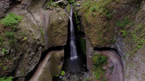 Aerial-view-of-a-secluded-waterfall-embedded-into-a-cliff