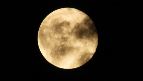 moon at night with cloud real time. 4k video moon in the black sky.  clouds passing by moon at night. night sky with cloudy weather