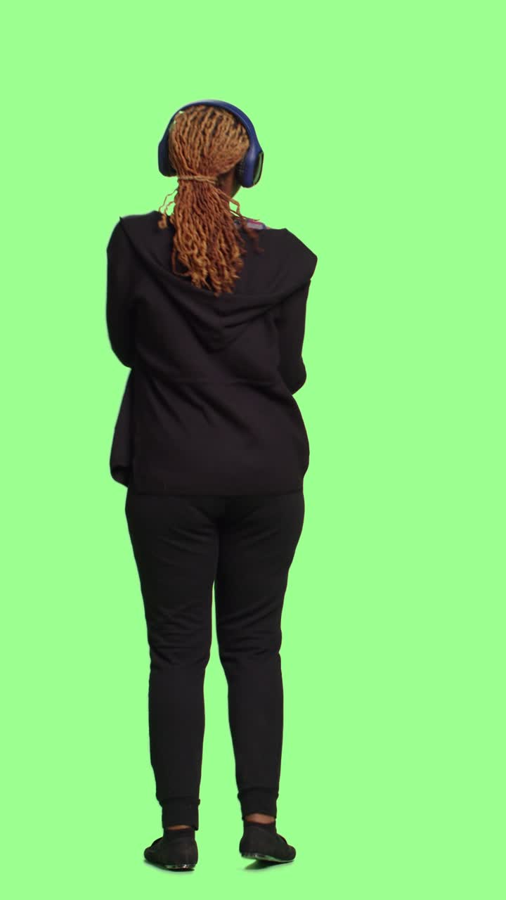 Vertical video: Happy female model listening to music on audio headset