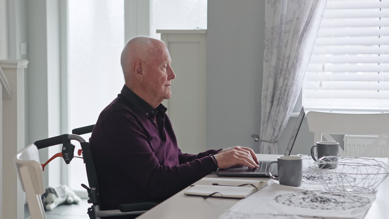 Elderly man using laptop at home