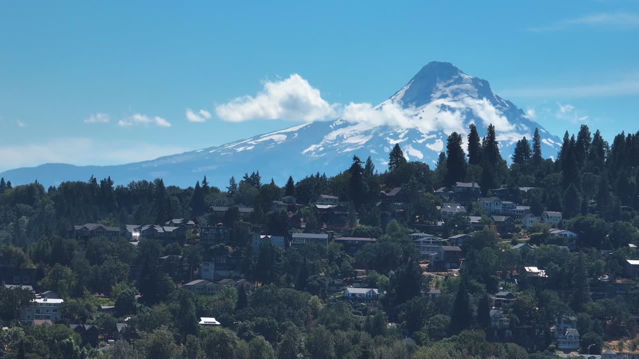 Telezoom aerial of houses with snowy Mount Hood background, in sunny Oregon, USA