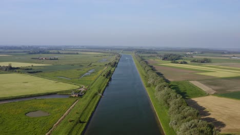 aerial shot of the canal through walcheren and surrounding agricultural land in zeeland, the netherlands, on a sunny summer day