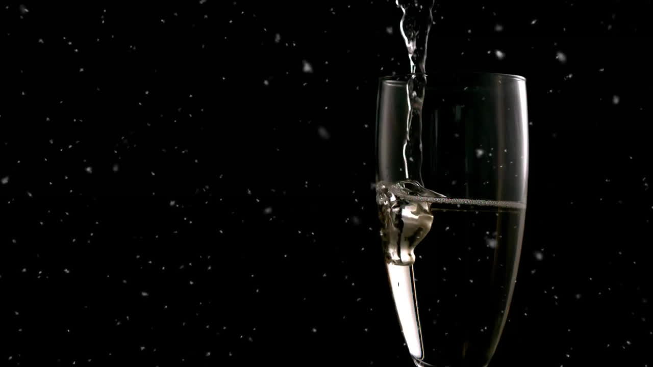 Pouring champagne into glass with falling snowflakes animation on black background