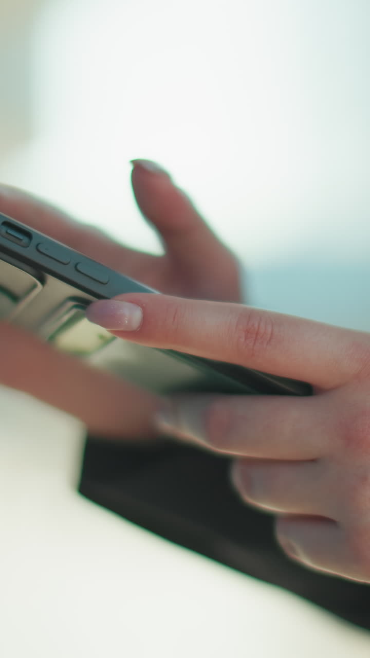 Close-up of lady sliding through phone screen, typing messages, with blurred building background in urban setting, highlighting business, productivity, and modern communication