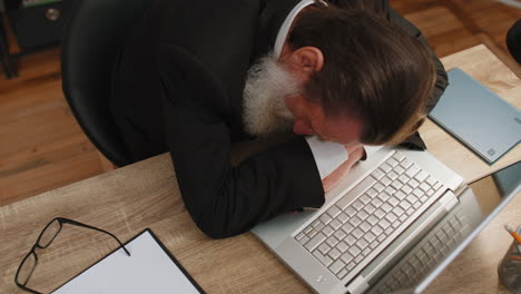 bored tired sleepy business man falling asleep after routine work on laptop computer at office desk